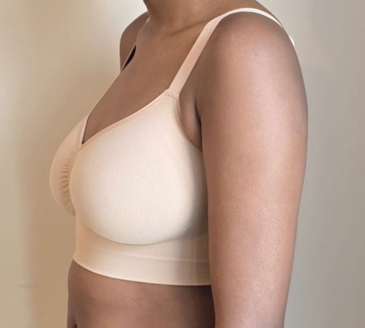 Beige bra worn by a person on a neutral background